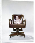 1960s chubby baby in diaper sitting in office executive chair by Anonymous