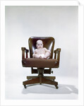 1960s chubby baby in diaper sitting in office executive chair by Anonymous