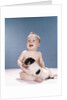 1960s smiling baby girl sitting in diapers playing with young black and white puppy dog by Anonymous