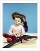 1960s baby boy wearing coonskin cap with stuffed animal and shotgun by Anonymous