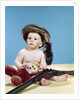 1960s baby boy wearing coonskin cap with stuffed animal and shotgun gun by Anonymous