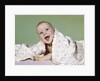 1960s smiling happy baby peeking out from under a blanket by Anonymous