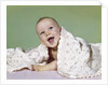 1960s smiling happy baby peeking out from under a blanket by Anonymous