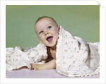 1960s smiling happy baby peeking out from under a blanket by Anonymous