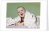 1960s smiling happy baby peeking out from under a blanket by Anonymous