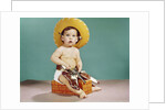 1960s baby wearing cowboy hat and holster with guns pistols looking at camera by Anonymous