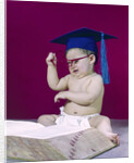 1960s graduate baby wearing mortarboard eyeglasses reading book by Anonymous