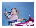 1960s smiling baby holding eyeglasses by Anonymous