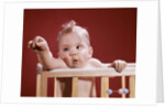 1960s baby reaching out from crib by Anonymous