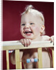 1960s laughing blond baby in crib or playpen by Anonymous