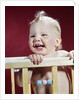 1960s laughing blond baby in crib or playpen by Anonymous