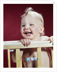 1960s laughing blond baby in crib or playpen by Anonymous