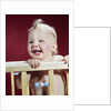 1960s laughing blond baby in crib or playpen by Anonymous