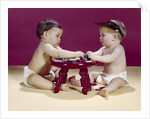 1960s two babies sitting at red stool playing cards poker with gambling chips by Anonymous