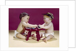 1960s two babies sitting at red stool playing cards poker with gambling chips by Anonymous