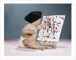 1960s baby artist wearing black beret sitting in front of easel painting by Anonymous