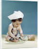 1960s baby wearing nurse nurse's cap stethoscope listening to doll heartbeat chest by Anonymous