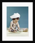 1960s baby wearing nurse nurse's cap stethoscope listening to doll heartbeat chest by Anonymous