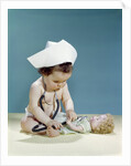 1960s baby wearing nurse nurse's cap stethoscope listening to doll heartbeat chest by Anonymous