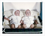 1950s 1960s twin boys dressed in white lying in stroller side by side by Anonymous