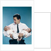 1960s father holding twin babies infants looking down at one of them by Anonymous