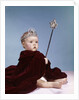 1960s baby girl wearing rhinestone tiara and red velvet cloak holding scepter by Anonymous