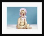 1960s baby wearing pink checked bonnet laughing by Anonymous