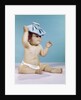 1960s baby sitting with ice pack on top of head by Anonymous