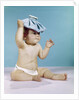 1960s baby sitting with ice pack on top of head by Anonymous