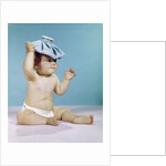 1960s baby sitting with ice pack on top of head by Anonymous