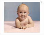 1970s smiling happy baby crawling straight ahead on pink blanket looking at camera by Anonymous