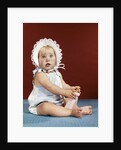 1960s baby girl ruffled bonnet holding bottle funny facial expression looking at camera by Anonymous