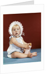 1960s baby girl ruffled bonnet holding bottle funny facial expression looking at camera by Anonymous