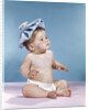 1960s baby sitting with ice pack on top of head by Anonymous