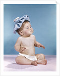 1960s baby sitting with ice pack on top of head by Anonymous