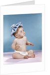 1960s baby sitting with ice pack on top of head by Anonymous