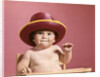 1960s baby making face wearing red straw hat by Anonymous