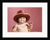 1960s baby making face wearing red straw hat by Anonymous