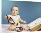 1960s baby holding eyeglasses with open dictionary and magnifying glass research by Anonymous