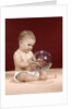 1960s baby sitting holding clear plastic toy ball with butterflies inside by Anonymous