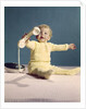 1960s baby holding telephone head set by Anonymous