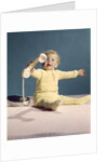1960s baby holding telephone head set by Anonymous