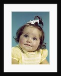 1960s brunette baby girl round chubby face yellow dress ribbon topknot interested sincere facial expression looking at camera by Anonymous