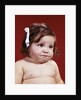 1960s portrait of chubby unhappy baby girl with white ribbon bow in messy hair by Anonymous
