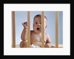 1960s baby in crib or playpen looking through bars alarmed expression by Anonymous