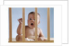 1960s baby in crib or playpen looking through bars alarmed expression by Anonymous