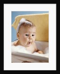 1960s baby with a surprised facial expression in bathtub covered with soap bubbles by Anonymous