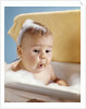 1960s baby with a surprised facial expression in bathtub covered with soap bubbles by Anonymous