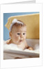 1960s baby with a surprised facial expression in bathtub covered with soap bubbles by Anonymous