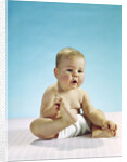 1960s baby sitting holding on to his feet by Anonymous